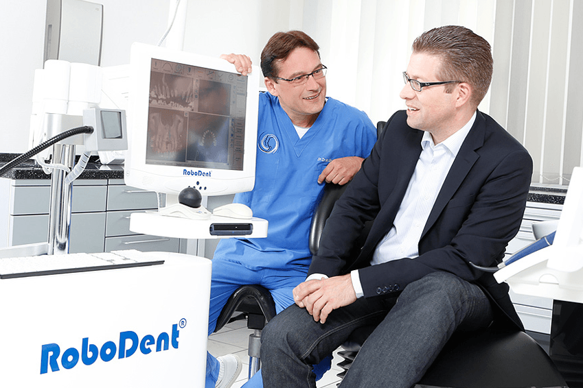 Praxisinhaber Maick Griebenow in Besprechung mit einem Patienten