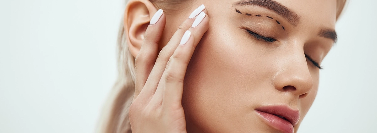 Plastische Chirurgie. Eine schöne junge blonde Frau mit geschlossenen Augen, die ihr Gesicht berührt, auf dem eine Skizze zu sehen ist.